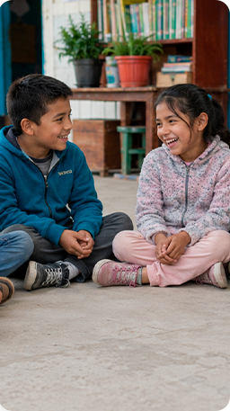 Niños sentados conversando y sonriendo